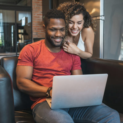 Young couple spending time together while using a laptop at home.